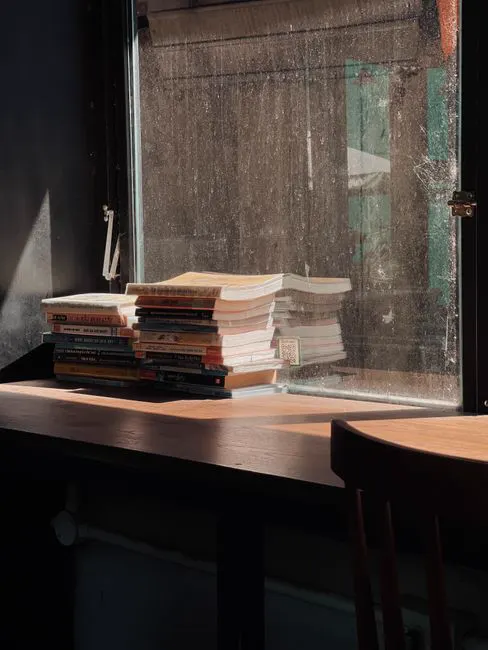 Stacked books in warm window light
