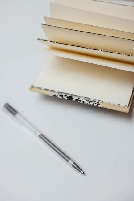 Open notebook and pen on a white desk